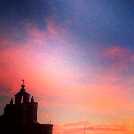 Vista de la espadaña de la iglesia de Gamones al atardecer