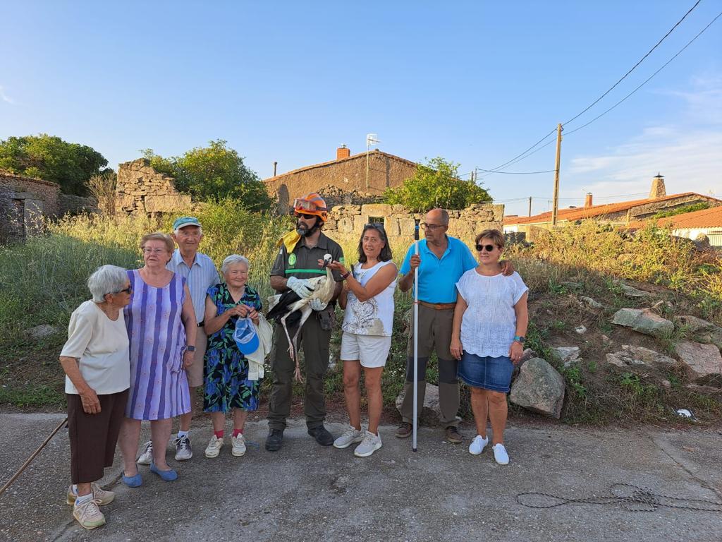 foto de agente medioambiental con cigueña junto a los vecinos y vecinas de Viñuela de Sayago (Zamora)