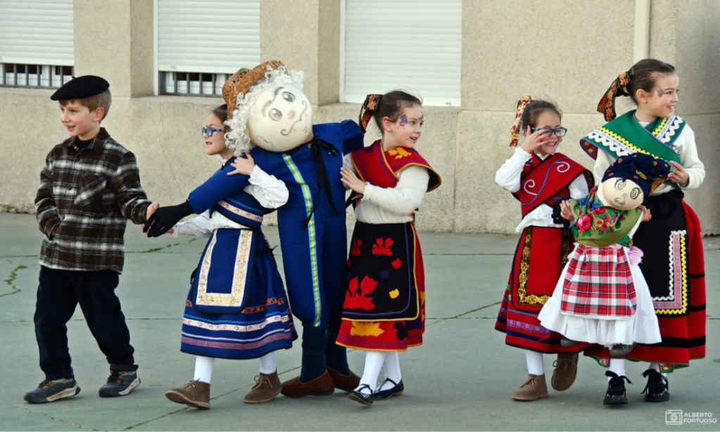 Niños vestidos con trajes tradicionales bailando en grupo, enseñando alegría y cultura popular.